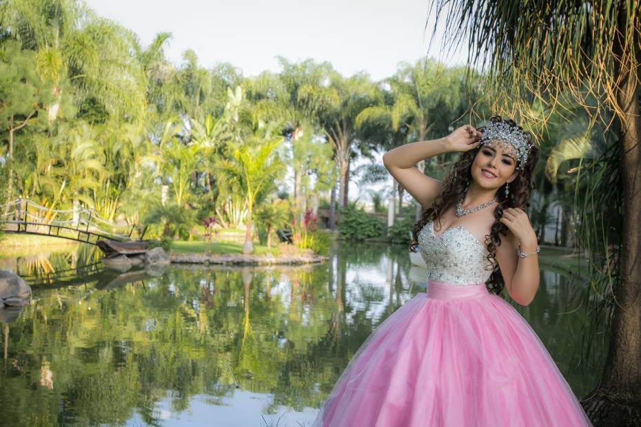 Quinceañera de frente posando su vestido de quinecañera rosa, sobre cómo elegir el peinado y maquillaje perfecto para tu vestido de quinceañera