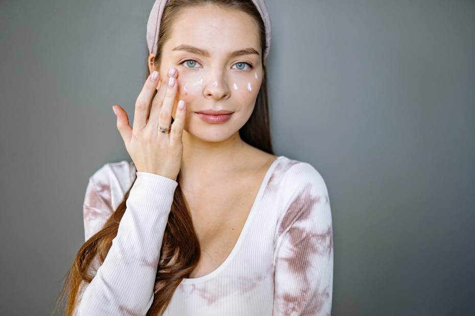 Mujer hidratándose la cara, sobre tips para lograr un maquillaje profesional