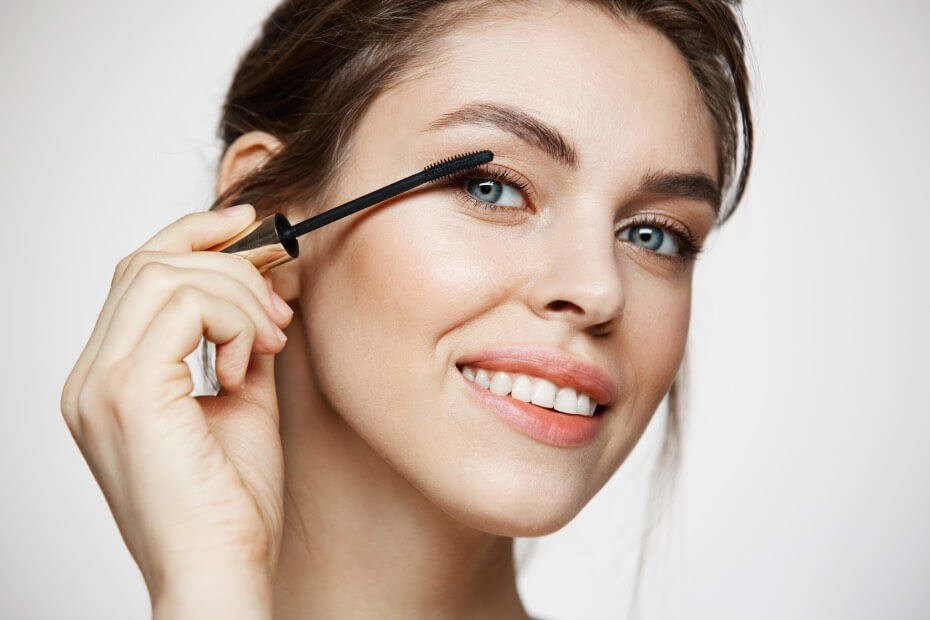 Dama de frente sonriendo con las pestañas perfectas, sobre tips de maquillaje para lucir radiante en la playa