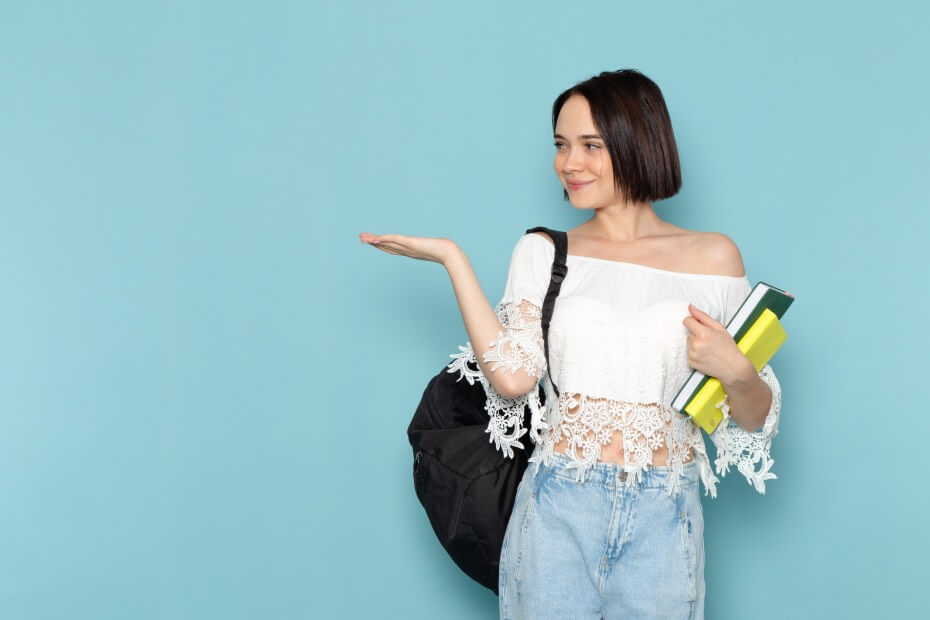 Mujer de frente sosteniendo libros para su regreso a clases, sobre domina el regreso a clases con estilo: 7 Tips para un maquillaje back to school