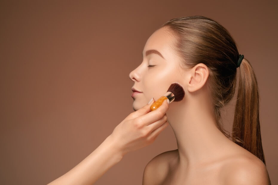 Mujer rubia aplicándoselos base de maquillaje para probar duración